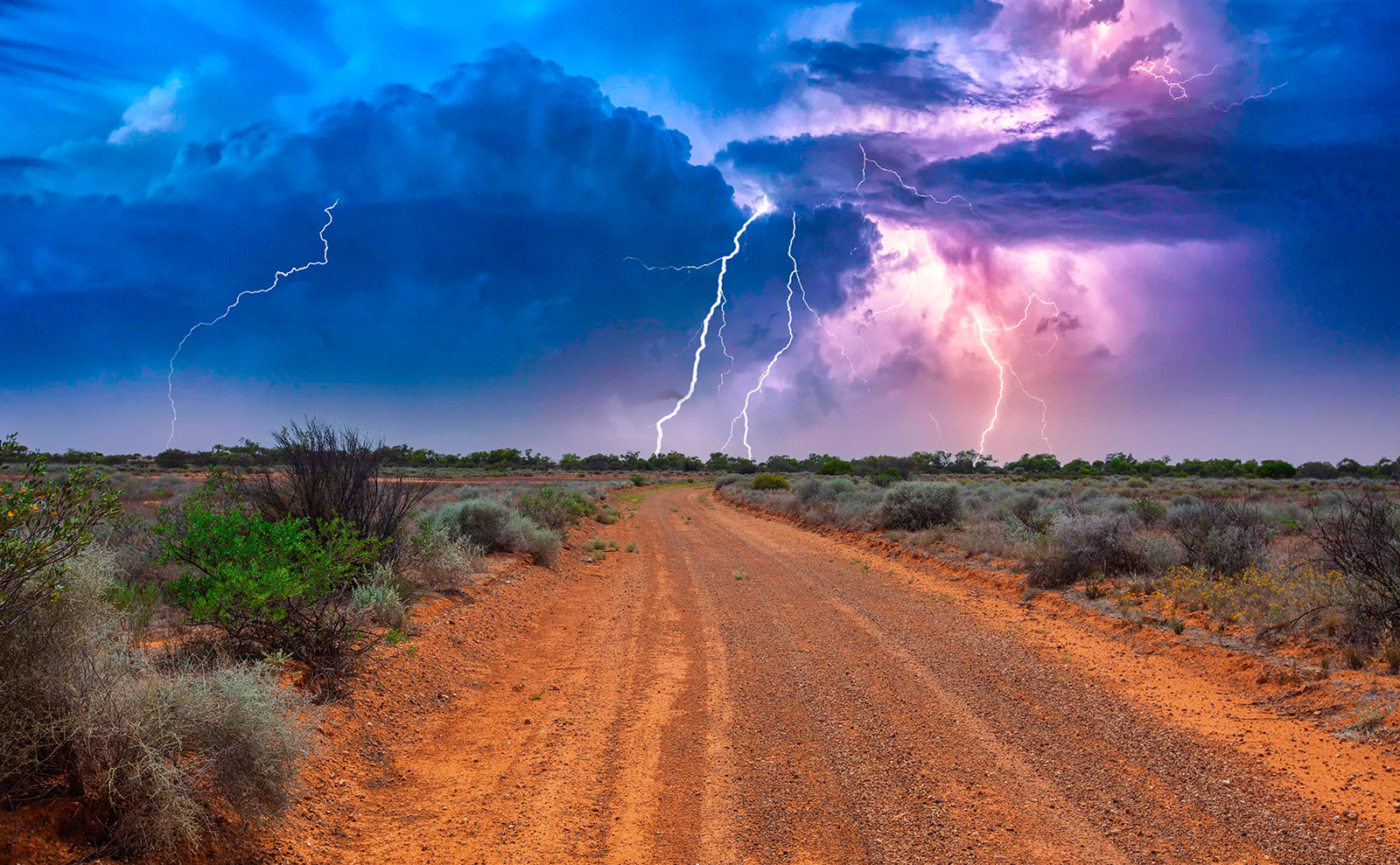 red sand of australian outback with lightning in the sky